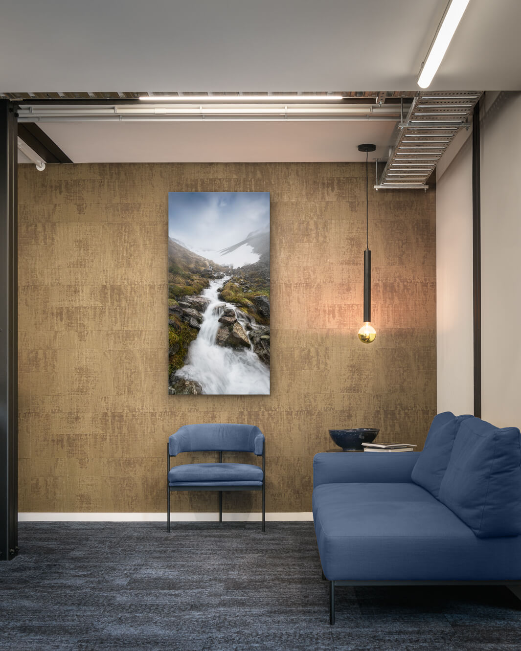 Canvas photo of New Zealand landscape on the wall of an industrial office with couch, chair and pendant light.