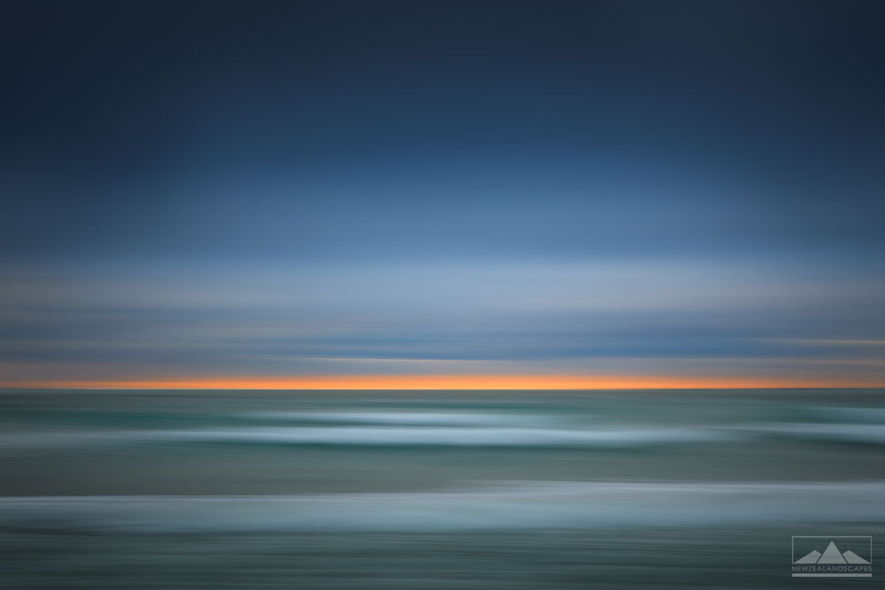 abstract seascape art photo of stripes of blue sea, orange sunrise and blue sky at Mount Maunganui.
