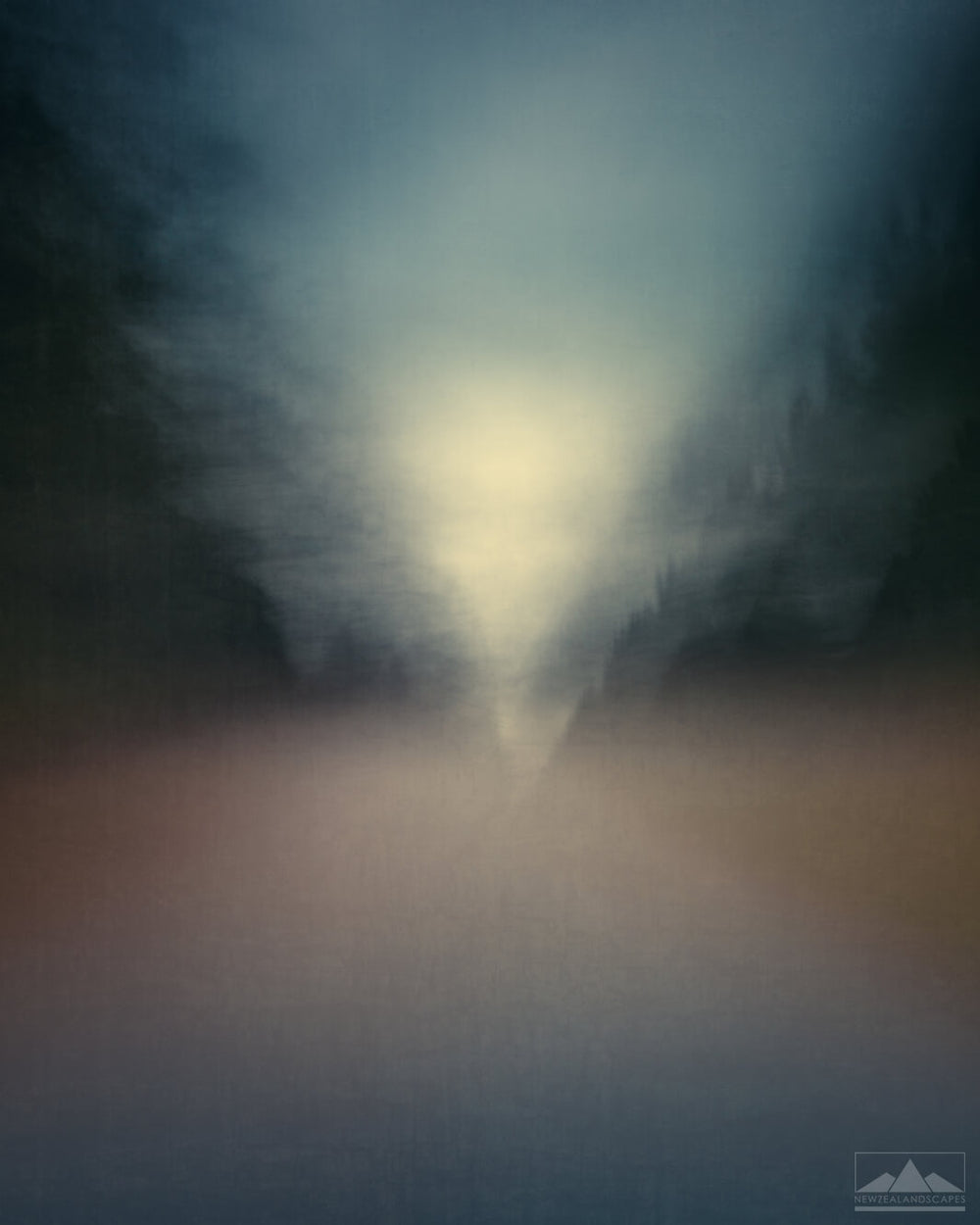 Abstract impressionist style blurred photo of a road inbetween trees, with sky and sunlight in the distance.